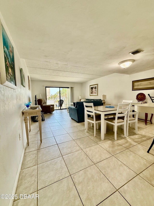 3800 S Atlantic Ave Unit 2010, Daytona Beach Shores, FL 32118 - dining room featuring light tile patterned flooring, a textured ceiling, and baseboards