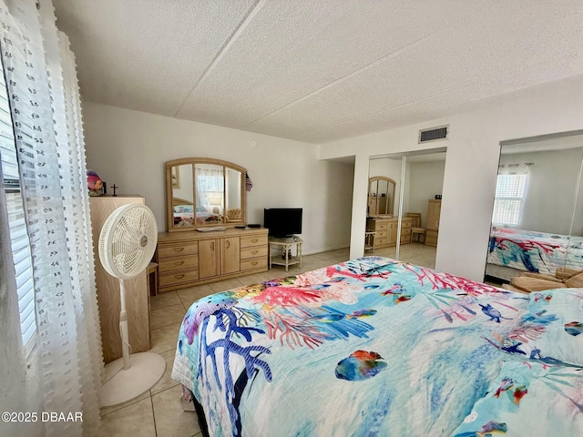 3800 S Atlantic Ave Unit 2010, Daytona Beach Shores, FL 32118 - bedroom with light tile patterned floors, a textured ceiling, and a closet