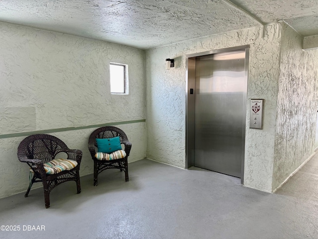 3800 S Atlantic Ave Unit 2010, Daytona Beach Shores, FL 32118 - sitting room featuring elevator, a textured wall, finished concrete flooring, and a textured ceiling