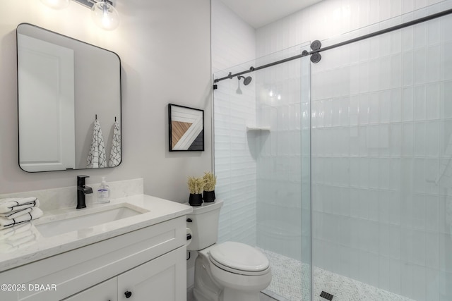 bathroom featuring toilet, an enclosed shower, and vanity