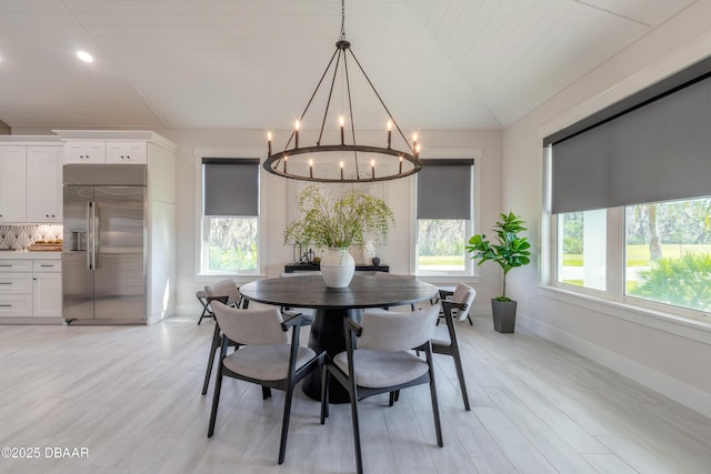 dining area with light hardwood / wood-style floors, plenty of natural light, and wooden ceiling