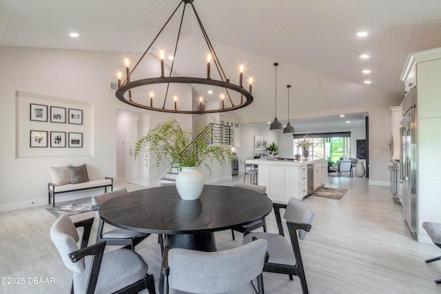 dining room featuring light wood-type flooring, a notable chandelier, and vaulted ceiling