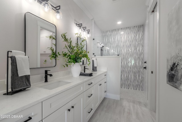 bathroom featuring hardwood / wood-style floors, tiled shower, vanity, and crown molding