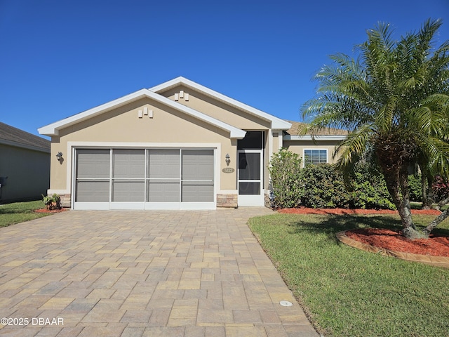 single story home with stone siding, decorative driveway, an attached garage, and stucco siding