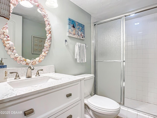 bathroom with toilet, an enclosed shower, and vanity