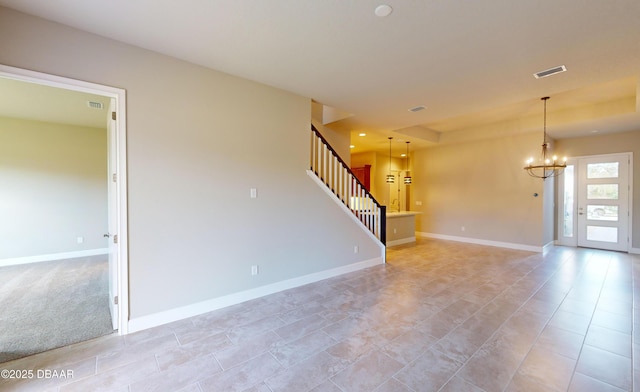 unfurnished room featuring a chandelier