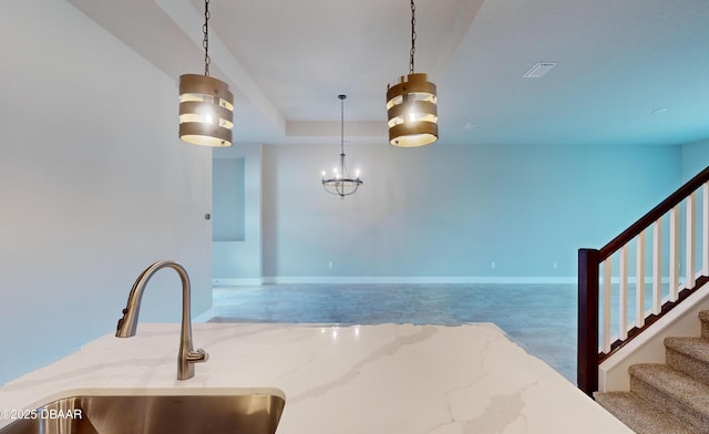 kitchen with hanging light fixtures and light stone countertops