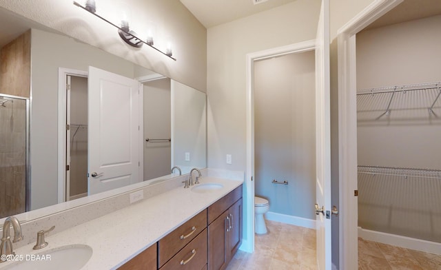 bathroom featuring vanity, toilet, and an enclosed shower