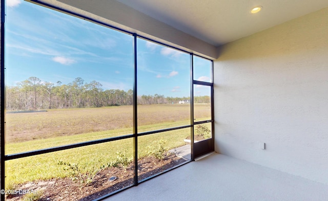 unfurnished sunroom featuring a rural view