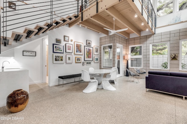 interior space featuring beam ceiling, sink, and a high ceiling