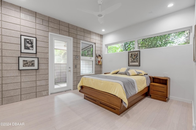 bedroom with ceiling fan, access to exterior, tile walls, and multiple windows