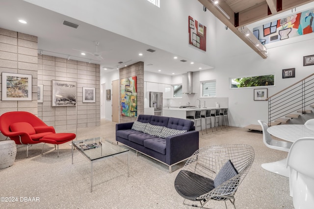 living room featuring tile walls and a high ceiling