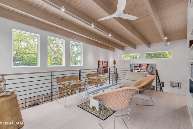 living room with beam ceiling, rail lighting, hardwood / wood-style flooring, and a wealth of natural light