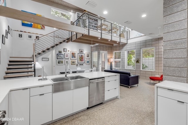 kitchen featuring a wealth of natural light, white cabinetry, sink, and stainless steel dishwasher