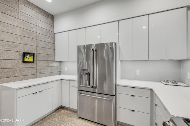 kitchen featuring white cabinetry, stainless steel fridge with ice dispenser, and backsplash