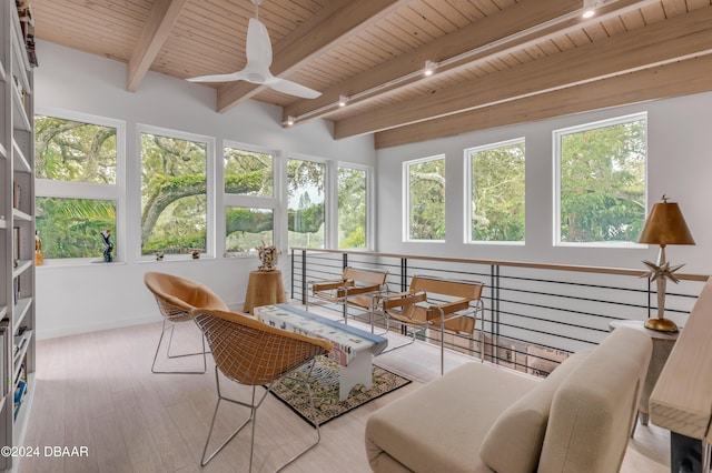 sunroom / solarium with beam ceiling, ceiling fan, and wooden ceiling