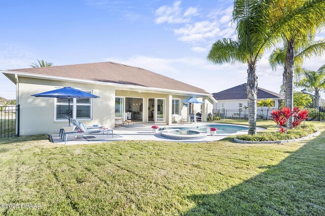 back of house with a swimming pool with hot tub, a patio, and a lawn