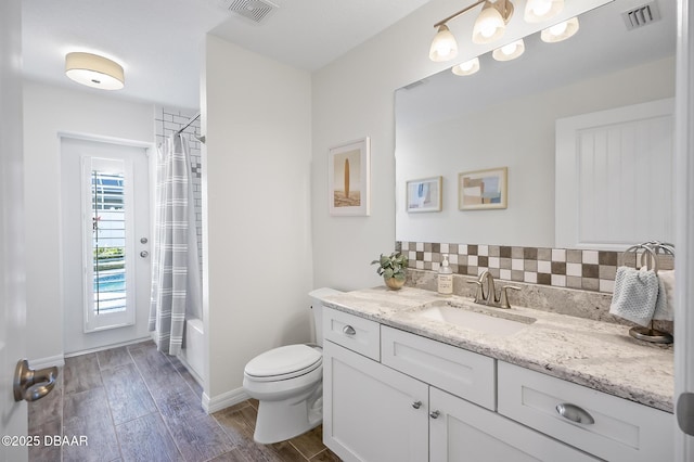 full bathroom featuring decorative backsplash, hardwood / wood-style flooring, vanity, toilet, and shower / bathtub combination with curtain