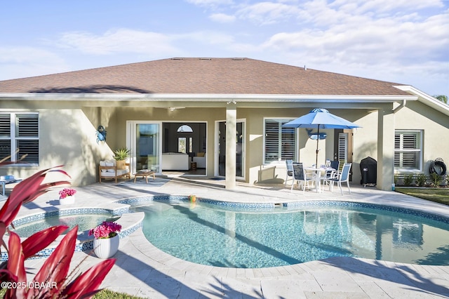 back of house with a swimming pool with hot tub and a patio area