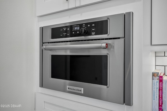 room details featuring oven and white cabinets