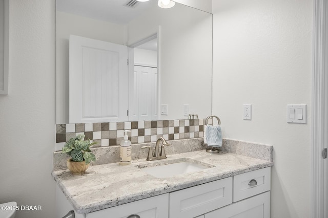 bathroom with vanity and decorative backsplash