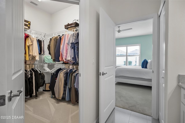 walk in closet featuring light carpet and ceiling fan