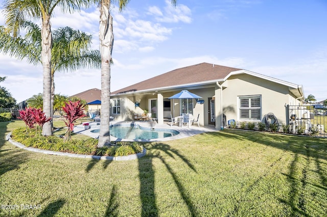 rear view of house featuring a yard, a fenced in pool, and a patio area