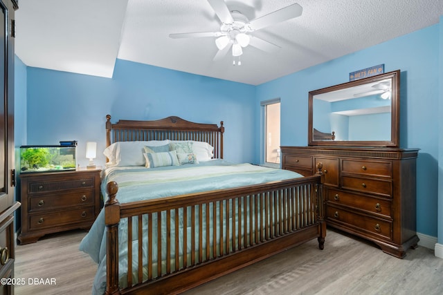 bedroom featuring a ceiling fan, baseboards, and wood finished floors