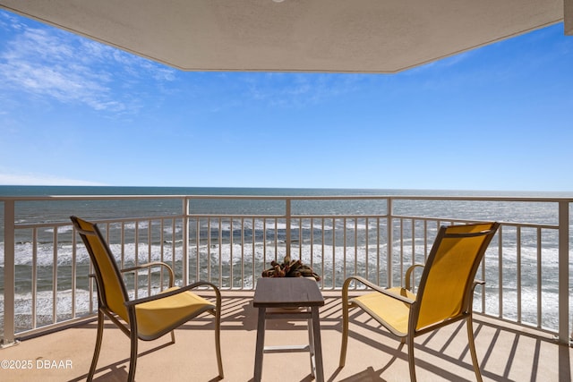 balcony featuring a beach view and a water view