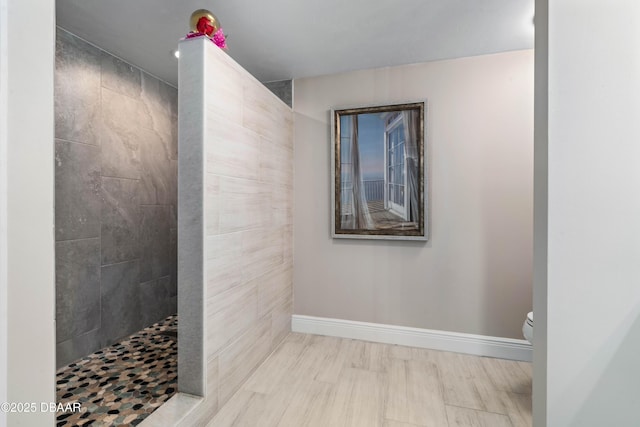 full bath featuring a walk in shower, toilet, and baseboards