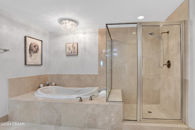 bathroom with an inviting chandelier and separate shower and tub