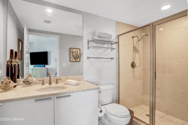 bathroom with vanity, toilet, and a shower with door