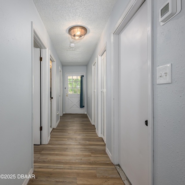 1635 Magnolia Ave, South Daytona, FL 32119 - hallway with a textured ceiling, baseboards, and wood finished floors