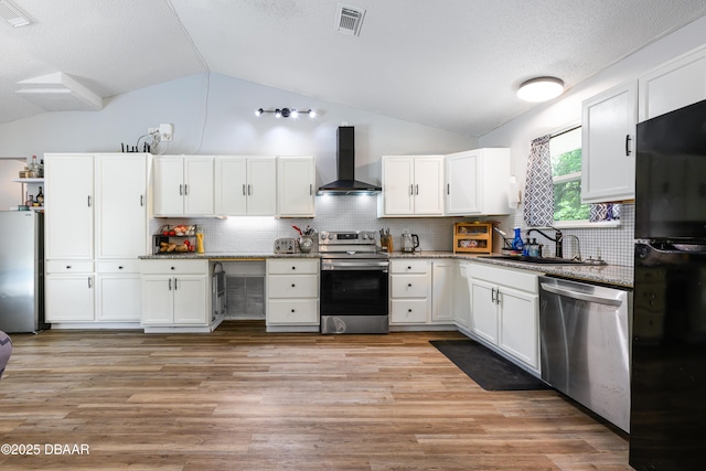 1635 Magnolia Ave, South Daytona, FL 32119 - kitchen with wall chimney range hood, visible vents, appliances with stainless steel finishes, a sink, and lofted ceiling