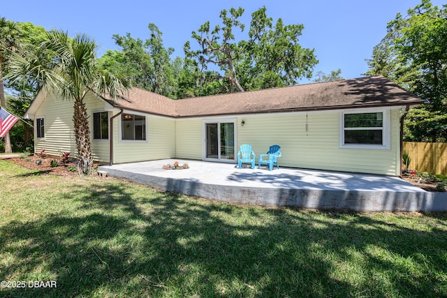1635 Magnolia Ave, South Daytona, FL 32119 - back of property featuring a patio, a yard, a shingled roof, and fence
