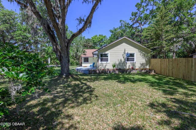 1635 Magnolia Ave, South Daytona, FL 32119 - rear view of house featuring fence and a lawn