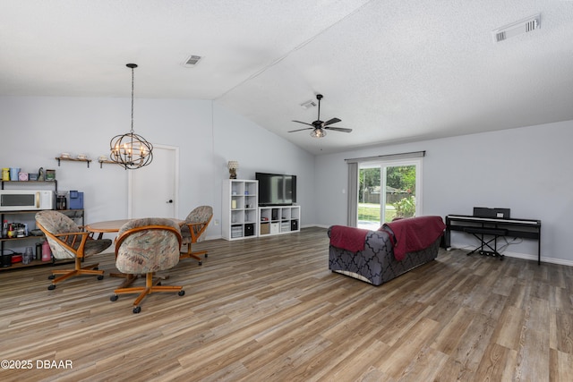 1635 Magnolia Ave, South Daytona, FL 32119 - living room with light wood-type flooring, visible vents, ceiling fan with notable chandelier, and lofted ceiling