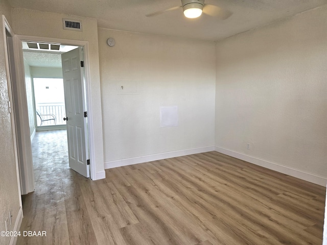 empty room with ceiling fan and light hardwood / wood-style floors