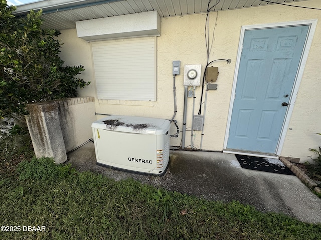 details featuring electric meter, a power unit, and stucco siding