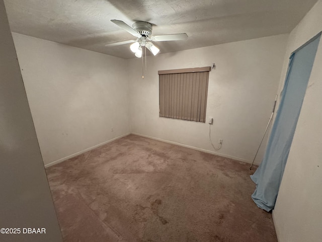 spare room featuring light carpet, ceiling fan, a textured ceiling, and baseboards