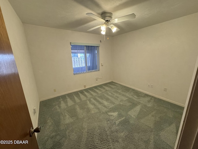 carpeted empty room with a ceiling fan and baseboards