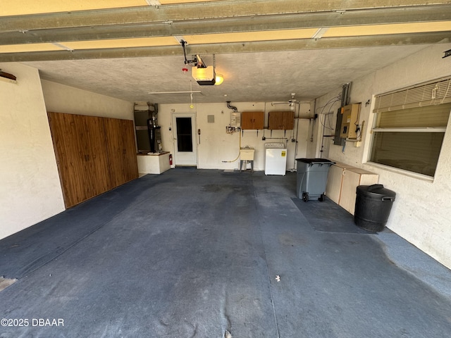 garage with washer / dryer, electric panel, a garage door opener, heating unit, and a sink