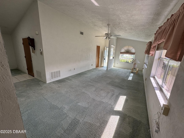 unfurnished living room with lofted ceiling, visible vents, a textured ceiling, and light colored carpet