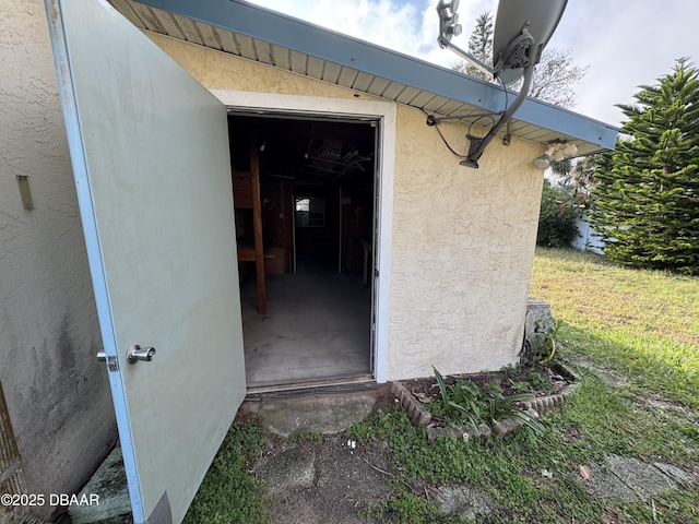 entrance to property featuring a yard and stucco siding