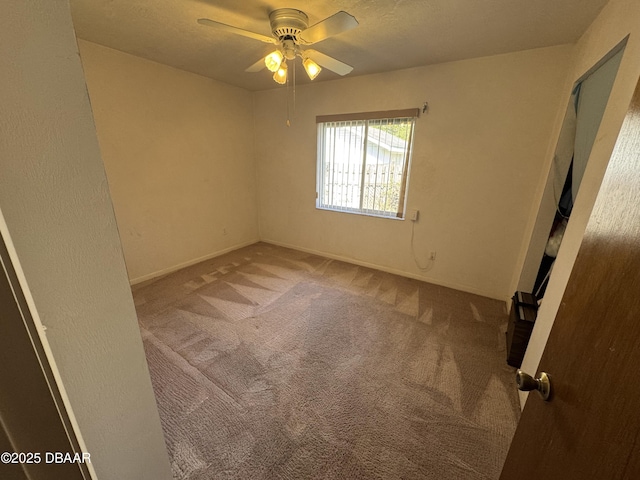 spare room with a ceiling fan and carpet flooring