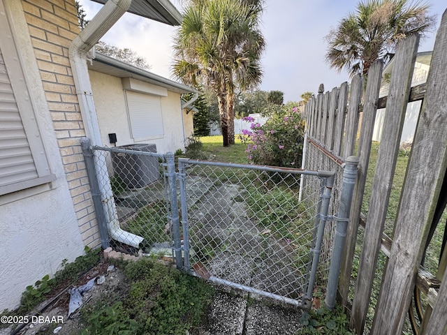 view of gate with cooling unit and fence