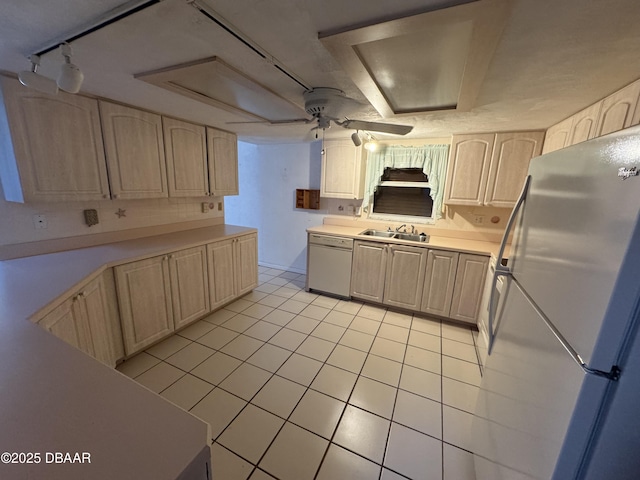 kitchen featuring light tile patterned floors, light countertops, light brown cabinetry, a sink, and white appliances