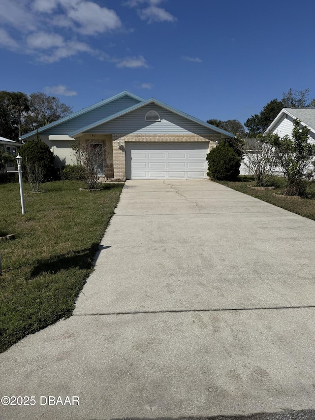 view of front of house with an attached garage, a front lawn, concrete driveway, and brick siding