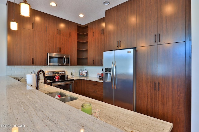 kitchen with light stone counters, sink, backsplash, and stainless steel appliances