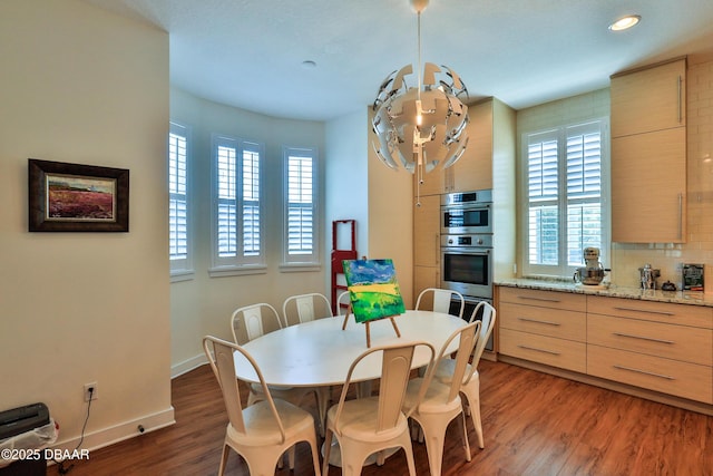 dining area featuring plenty of natural light, dark wood-type flooring, and a chandelier